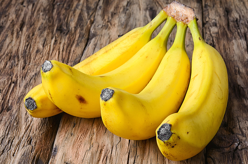 bunches of ripe bananas on vintage wooden background