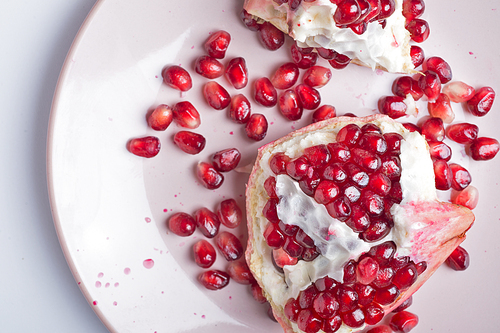 ripe cuting pomegranate at plate around white background