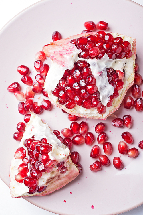 ripe cuting pomegranate at plate around white background