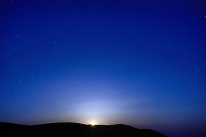 Blue dark night sky with many stars. Moon rising. Space background