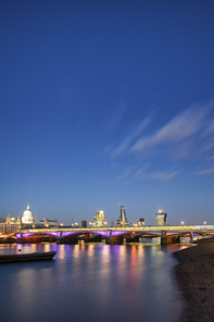 Stunning London City skyline landscape at night with glowing city lights and iconic landmark buldings and locations
