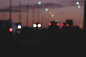 Streets in urban night with silhouettes of cars with defocused head and tail lights