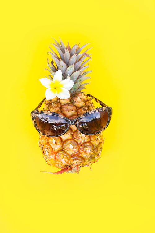 Summer flat lay with funny pineapple on yellow background