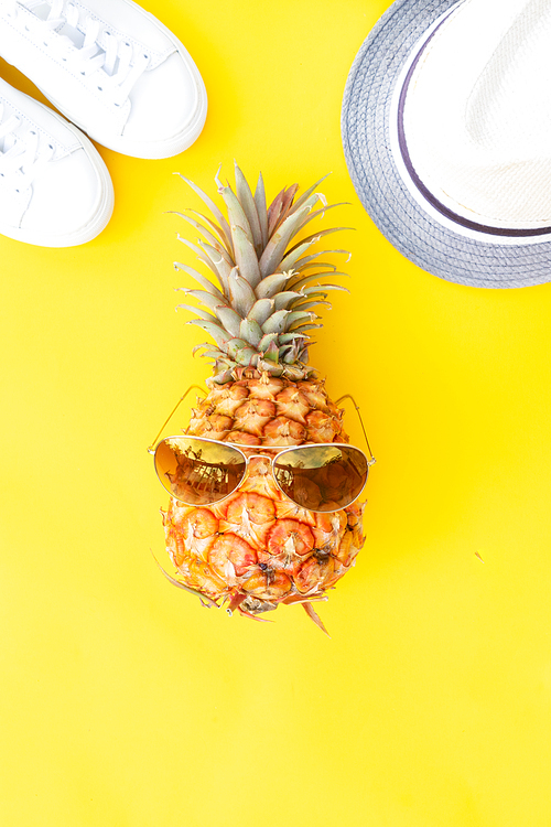 Summer flat lay pattern with funny pineapple on yellow background