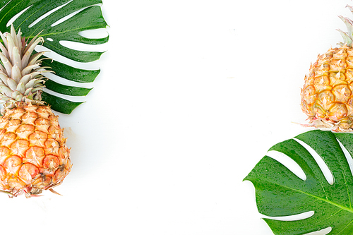 Tropical friuts and leaves on wooden background with copy space, top view