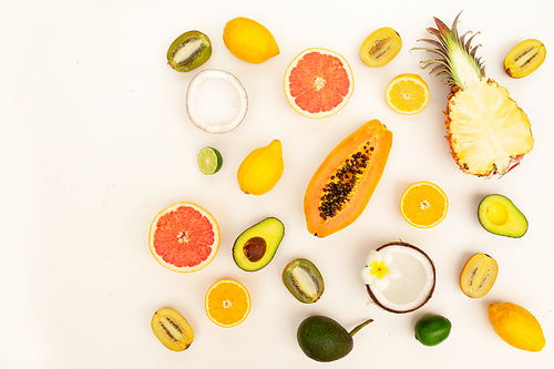 fresh tropical fruits halves food pattern flat lay scene, summer diet border with copy space