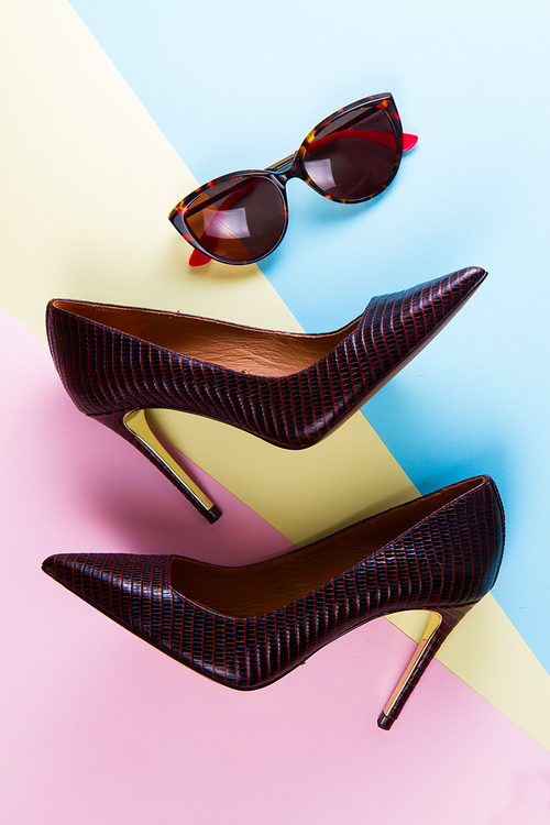Pair of elegant high heel shoes and sun glasses, flat lay style