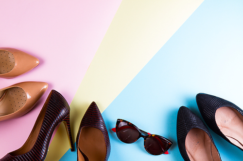 Elegant pairs of high heel shoes and sunglasses, flat lay style
