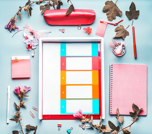 Creative Stylish office table desk with supply, diary,flowers on blue background. Flat lay, top view