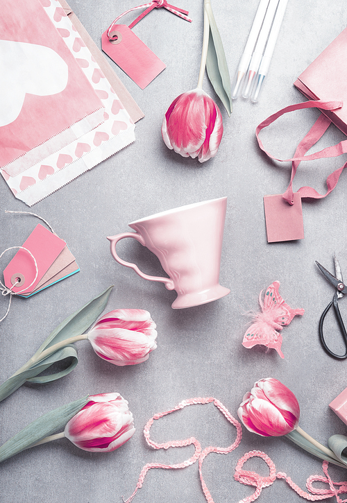 Springtime still life flat lay with pastel  pink tulips, hearts, mug , gifts, tags and scissors, top view. Layout or greeting card for Mothers day,birthday, Valentine's Day, wedding or happy event