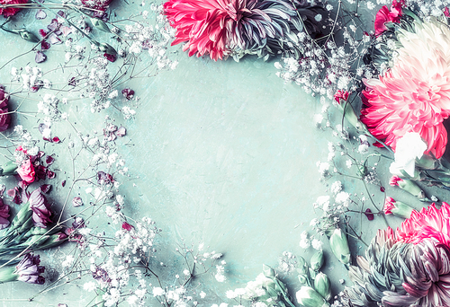 Floral frame background with romantic flowers on light blue with pink , top view