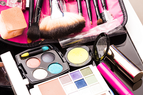Close up brushes and cosmetic products on the table, vivid colors