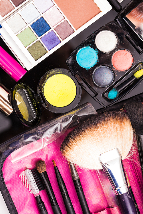 Close up brushes and cosmetic products on the table, vivid colors
