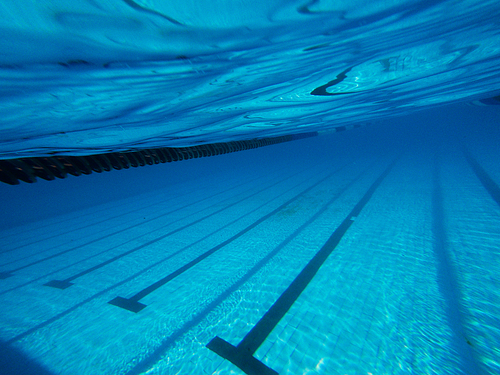 Underwater shotof swimming poolwith rippleson surface and lanes on the bottom