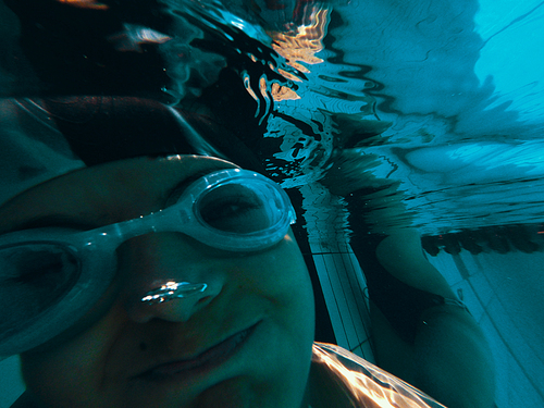 Face of a funny boy underwater in pool