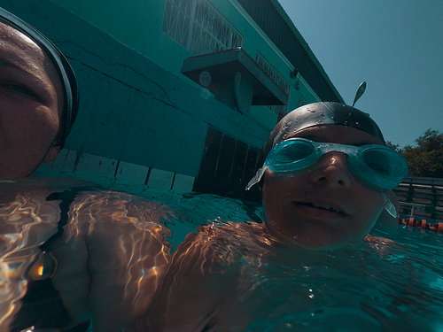 Mum and son in swimming pool action cam shot