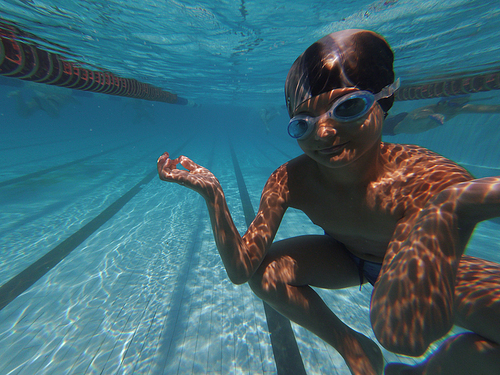 Boy posing underwater in swimming pool, copyspace