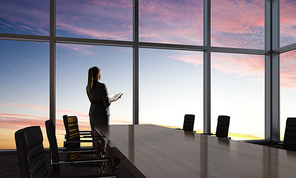 Businesswoman in night office against panoramic window in light of sunset