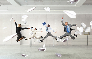 Happy young businesspeople running away from office