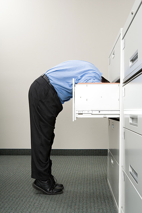 Man looking in filing cabinet