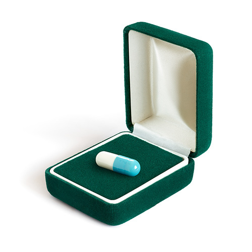 Creative concept photo of a jewellery box with a pill on white background.
