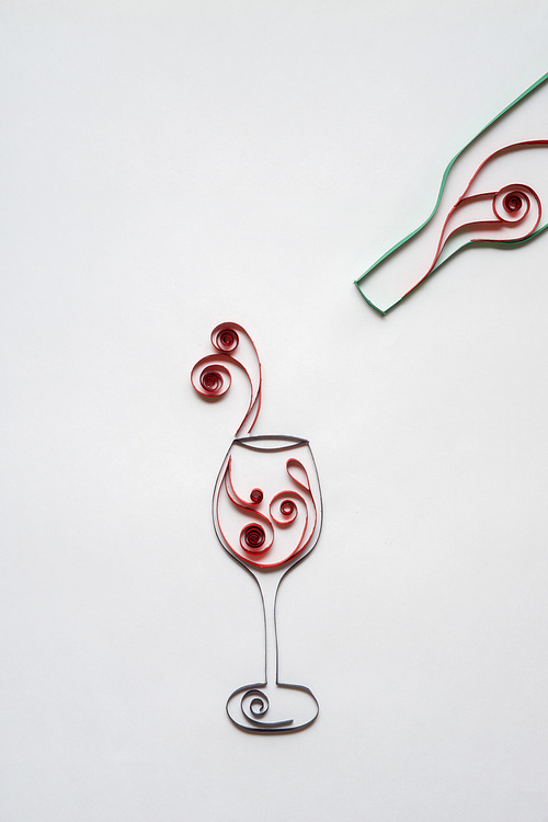 Creative concept photo of glass and bottle with win mad of paper on white background.