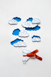 Creative concept photo of girl with clouds made of paper on white background.