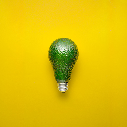 Creative concept photo of avocado as electric bulb on yellow background.