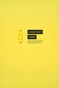 Creative concept photo of a paper clip on yellow background.