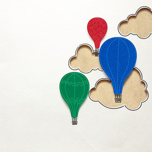 Creative concept photo of clouds and aerostats made of paper on white background.
