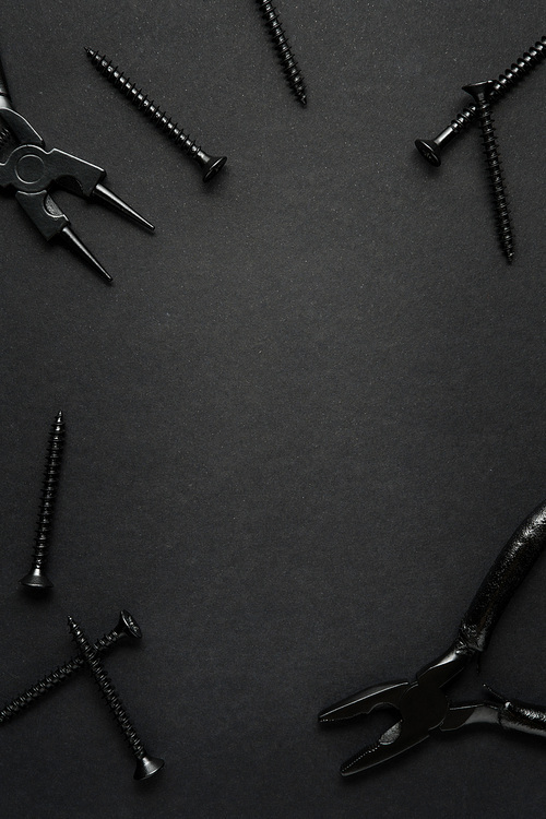 Creative concept photo of painted tools and nails on black background.