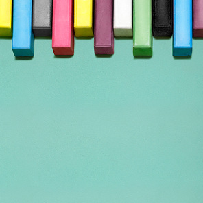 Creative still life of multicolored chalks arranged in a row like piano keys.