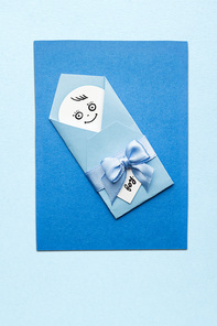 Creative photo of a child mad of paper on blue background.