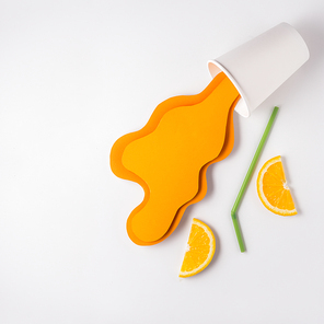 Creative concept photo of take away cup with splashing orange juice made of paper on grey background.