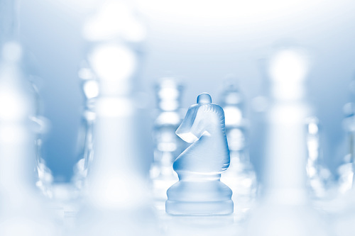 A conceptual photo of a transparent knight on a chessboard making an l-shaped move.