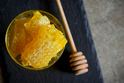 Fresh Honeycomb in glass and honey stick