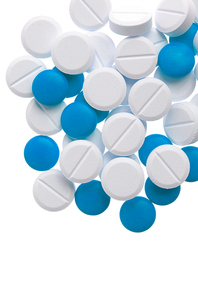 Macro view of white and blue pills on blue background.