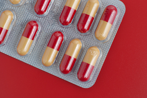 Macro view of red and yellow pills on red background.