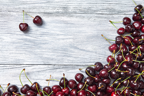 Natural organic fruits - ripe juicy red cherry on a gray old wooden background. Top view