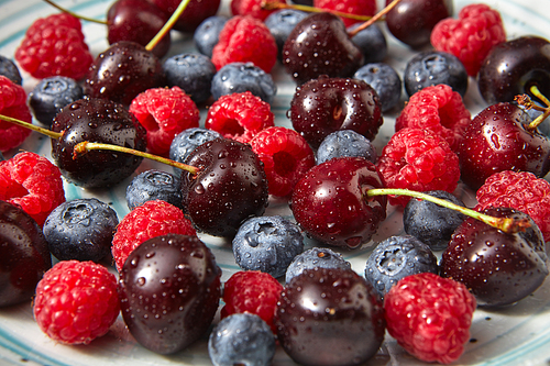 Ripe sweet berries, drops of water on them. Natural organic berries close-up background. Concept of healthy eating.