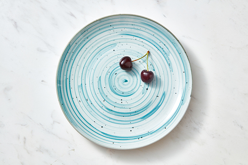 Tasty summer natural fresh fruits cherries on a blue plate. Concept of clean organic eating. Flat lay.
