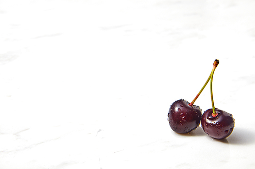 Tasty berries, freshly picked cherries on a concrete background. Concept of healthy food with copy space.