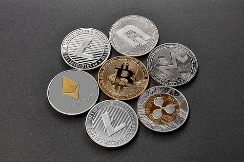 Gold and silver coins are monero, ripple, bitcoin, litecoin, ethereum, dash, on a black background. Cryptocurrency and blockchain trading concept. Top view