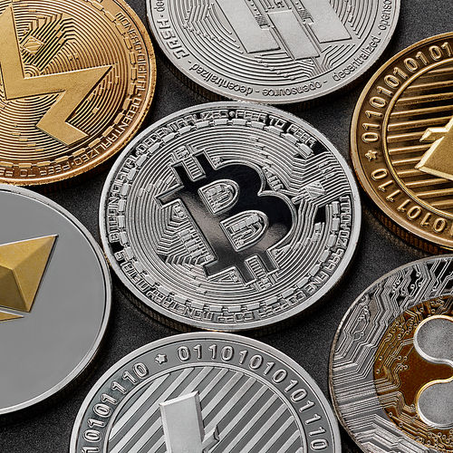 A pattern from different coins of crypto currency, bitcoin, ethereum, litecoin, monero, ripple, dash, against a dark background. Blockchain Technology. Business concept.