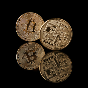 Bitcoin gold coins from face and back isolated on black background. Conceptual image for crypto currency market