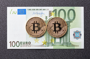 Gold coins bitcoin and one hundred euro banknote on a dark background. Exchange bitcoin cash for a dollar.