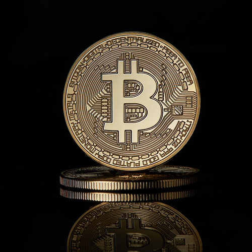 Stacked golden Bitcoin Cryptocurrency BTC Currency Technology Business Internet Concept on a black reflective surface background