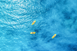 Aerial view of the people in kayaks in the blue sea at sunny bright day in summer. Zanzibar, Africa. Top view of canoe. Landscape with clear azure water, boats. Sport and leisure. Lifestyle