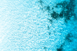 Aerial view of the blue sea at sunny bright day. Top view of the clear transparent water in summer. Natural background. Aerial landscape with ocean, stones on the sandy bottom. Nature