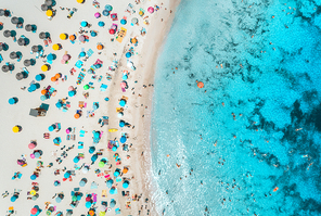 Aerial view of sandy beach with colorful umbrellas, swimming people, sea coast with transparent blue water at sunny day in summer. Travel in Mallorca, Balearic islands, Spain. Top view. Tropical